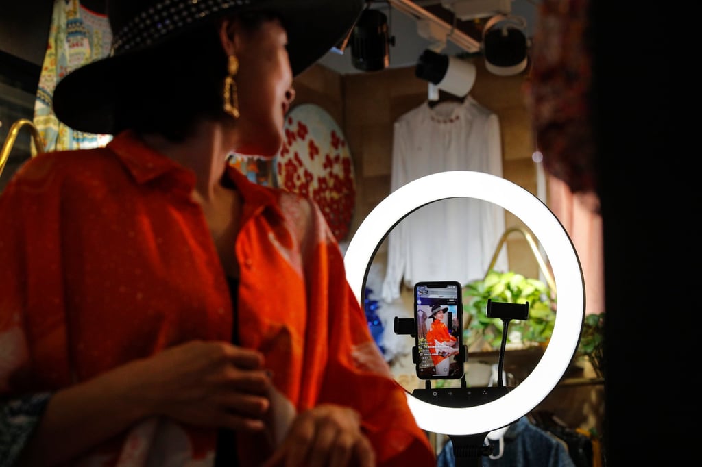 A retailer shows clothing to online shoppers during a live stream from her shop in Beijing in 2020. On Chinese platforms like Douyin, shopping, entertainment and conversation blur into an endlessly scrollable feed. Photo: AP