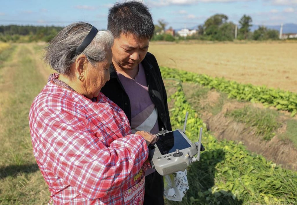After three of her five children moved to urban areas, Dai remained in the village alongside her eldest son and 40-year-old grandson, above, and together they manage over 40 hectares of farmland. Photo: Xinhua