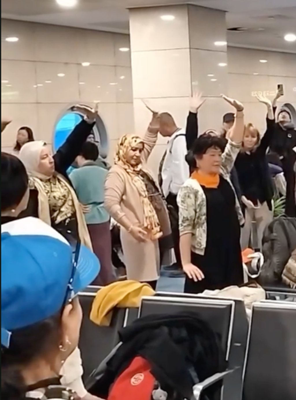 As time passed, more delayed passengers joined the impromptu qigong session. Photo: 8world