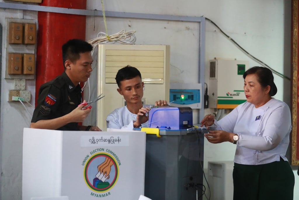 Volunteers and electoral officials collect ballots from an electronic voting machine after closing the second phase of the general election at a polling station in Yangon, Myanmar, on Sunday. Photo: EPA