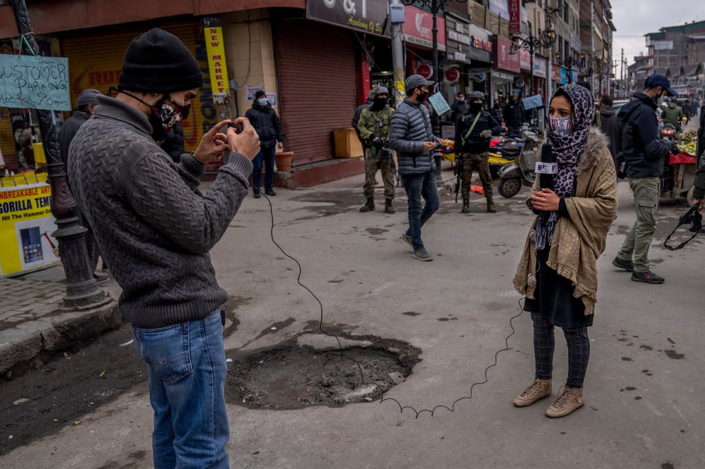 Kashmiri Journalists work during surprise search of pedestrians by security forces in Srinagar, Indian controlled Kashmir in January 2022. Photo: AP