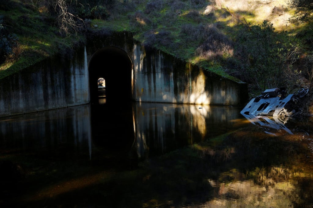 A metal piece is partly submerged in a stream near the crash site in Spain. Photo: Reuters