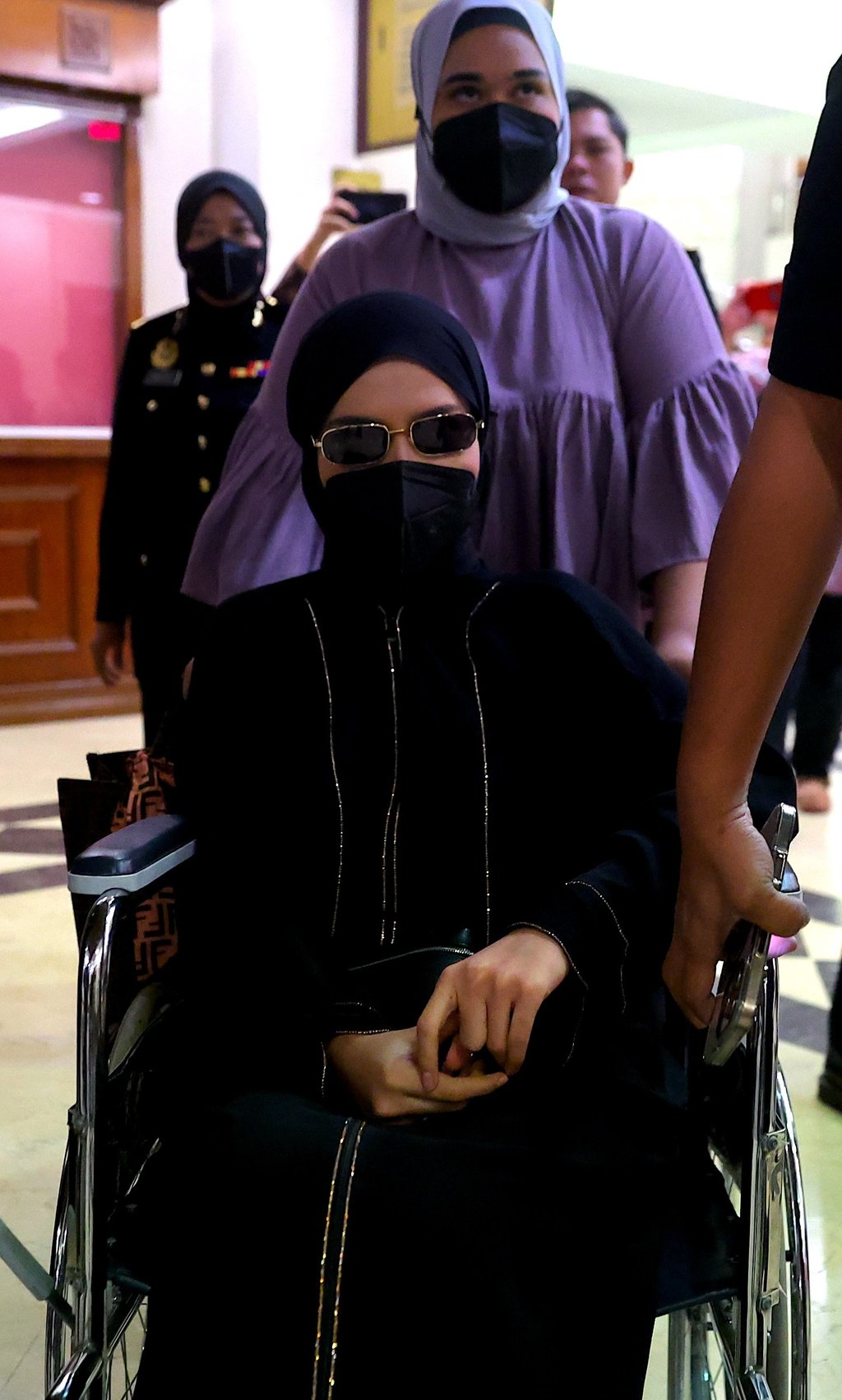Salwani Anuar enters court in a wheelchair on Thursday. Photo: EPA