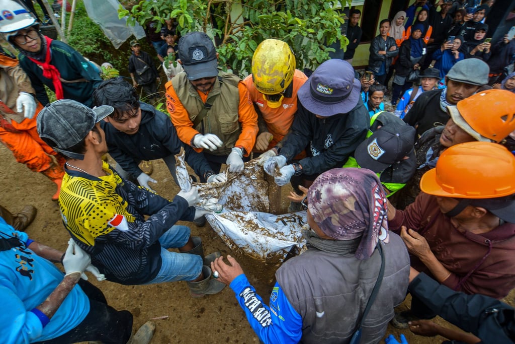 Rescuers carry a body bag containing the remains of a landslide victim onto an ambulance in Indonesia on Sunday. Photo: EPA-EFE