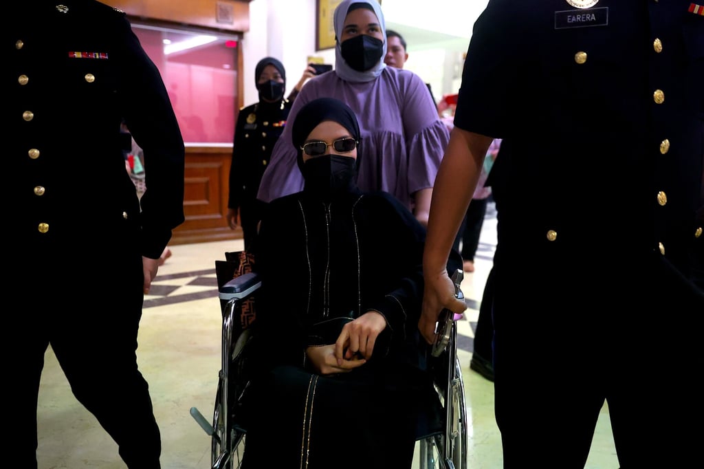 Salwani Anuar, wife of former Malaysian army chief Muhammad Hafizuddeain Jantan, arrives at the Kuala Lumpur Court in a wheelchair under escort by Malaysian Anti-Corruption Commission officers on January 22. Photo: EPA