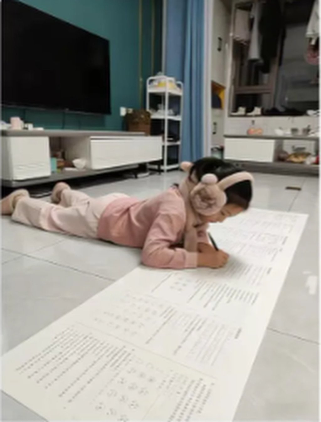 A child gets down to work on one of the huge homework papers. Photo: QQ.com
