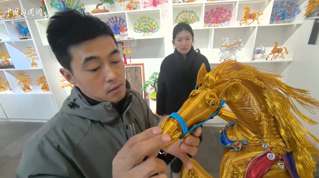 Yang Guang touches the finely crafted muzzle of his carefully put together horse. Photo: ChinaNews