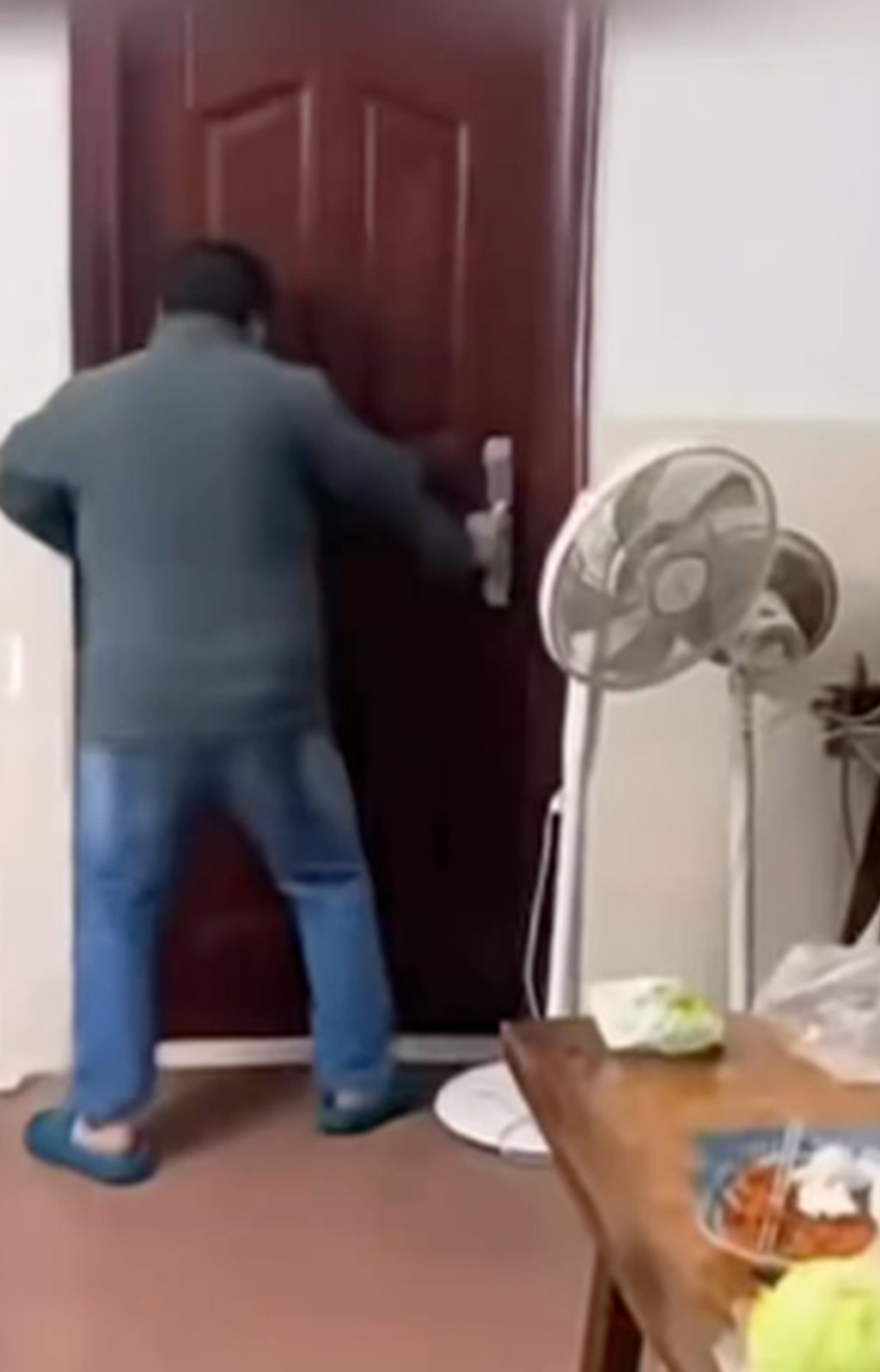 The enraged father rants outside his daughter’s bedroom door as she hides inside. Photo: The Paper