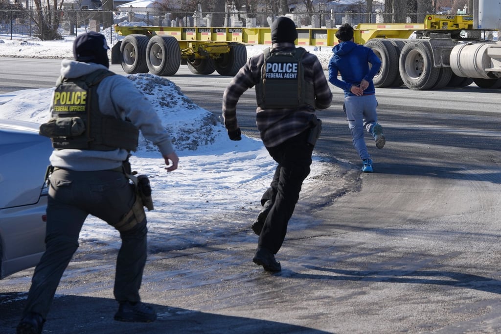A man in handcuffs runs from federal immigration agents in Minneapolis. Photo: AP