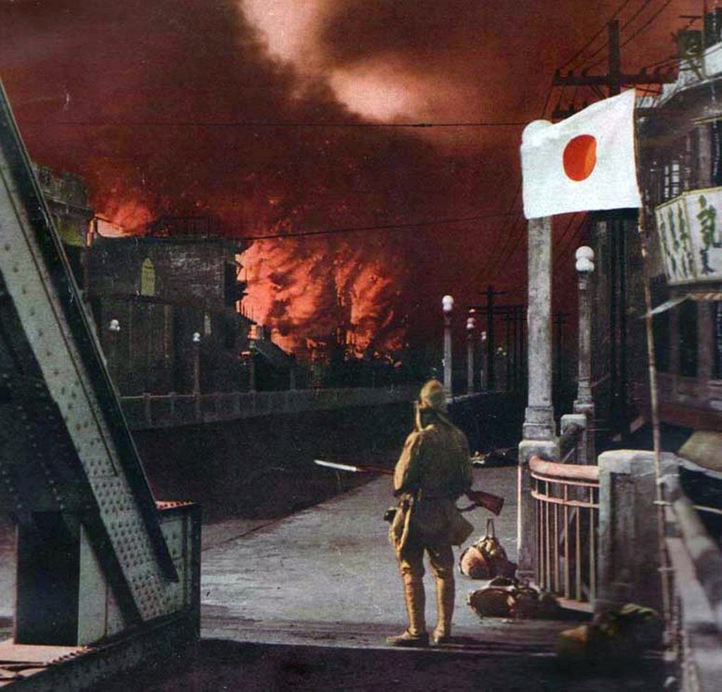 A Japanese soldier watches the suburbs of Shanghai ablaze during World War II in this undated colourised photograph. Photo: Getty Images