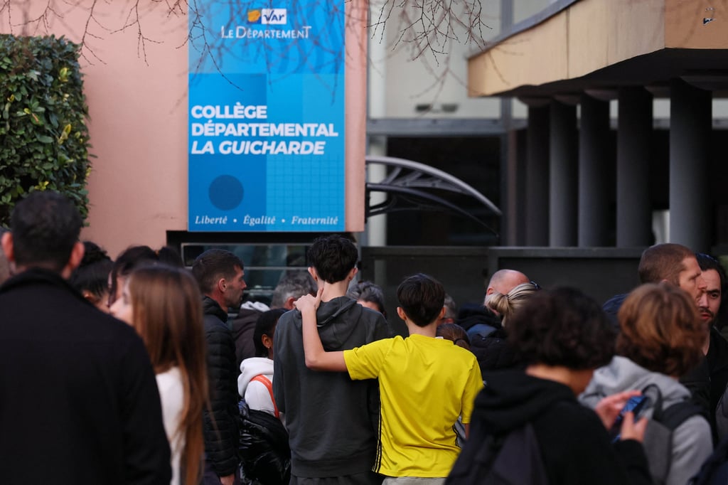 Students and their parents stand in front of the La Guicharde middle school after a teacher was stabbed on Tuesday. Photo: Reuters