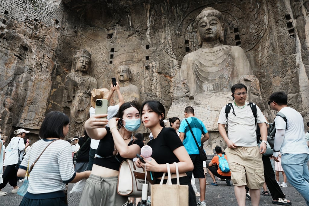 Tourists take a selfie with the Vairocana Buddha at Longmen Grottoes, a Unesco World Heritage site in China’s Henan province. Photo: Getty Images