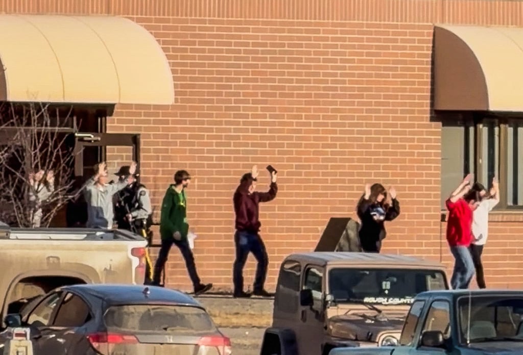 Students walk out of a school building with their hands up after a mass shooting in Tumbler Ridge, British Columbia, on Tuesday. Photo: Western Standard/Jordon Kosik via Reuters