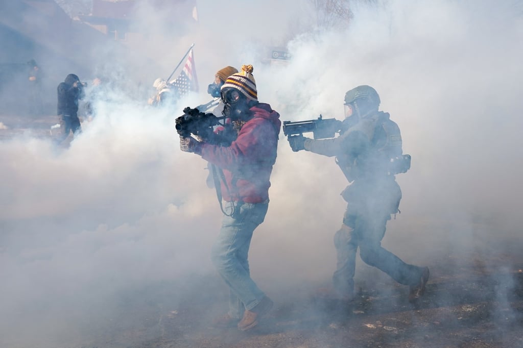 Federal officers move on protesters during a confrontation after ICE agents shot a man several times while they were trying to detain him in Minneapolis, Minnesota, last month. Photo: EPA