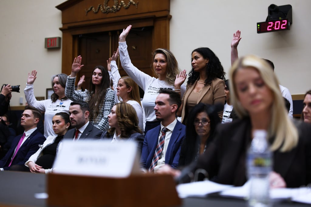 Epstein survivors stand and raise their hands as US Attorney General Pam Bondi (front, right) testifies before a House Judiciary Committee oversight hearing in Washington on Wednesday. Photo: AP