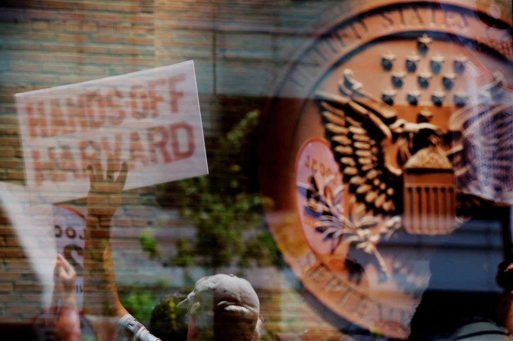 Demonstrators gathered to support Harvard University are reflected in a window of the federal courthouse in Boston, Massachusetts, in July 2025. Photo: Reuters