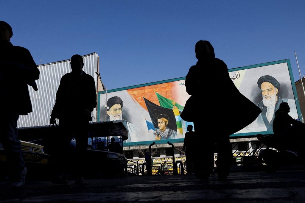 People walk near a mural featuring images of Iran’s Supreme Leader Ayatollah Ali Khamenei and leader of Iran’s 1979 Islamic Revolution Ayatollah Ruhollah Khomeini in Tehran on Tuesday. Photo: WANA via Reuters