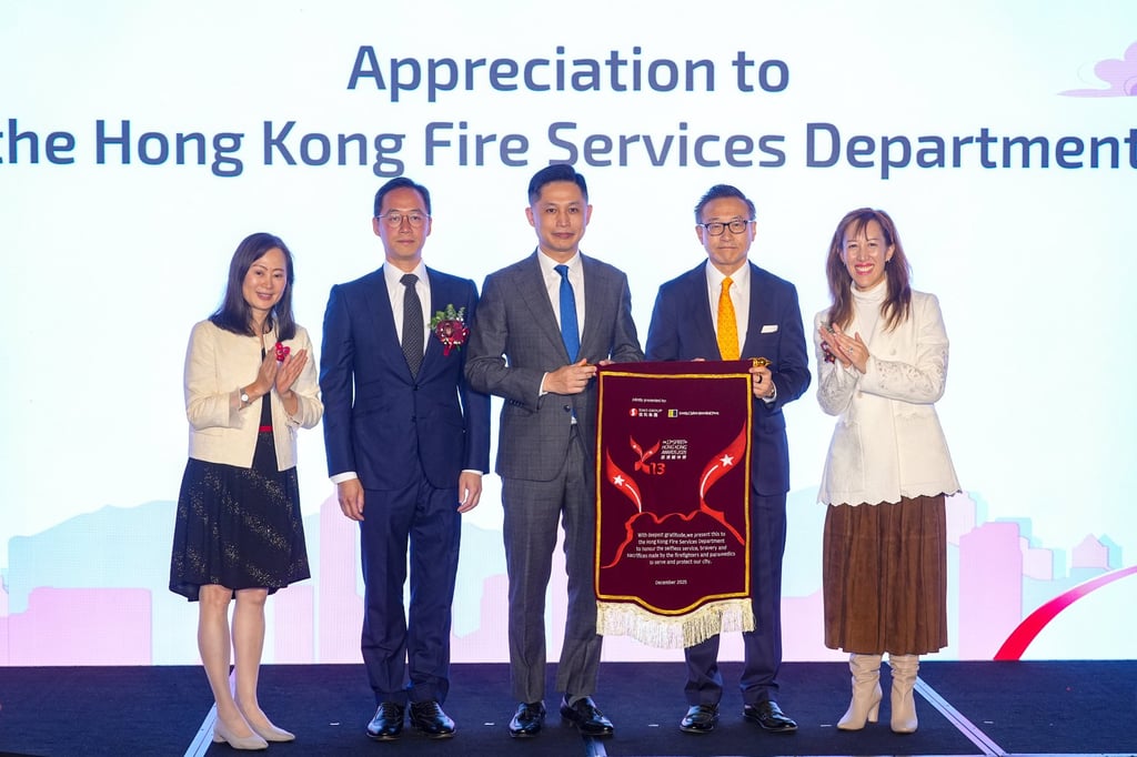 Alibaba’s Joe Tsai (second right) and fire services chief Andy Yeung hold the appreciation flag on stage, alongside the SCMP’s Tammy Tam (left), Ocean Park’s Paulo Pong (second left) and Sino Group’s Nikki Ng. Photo: Eugene Lee