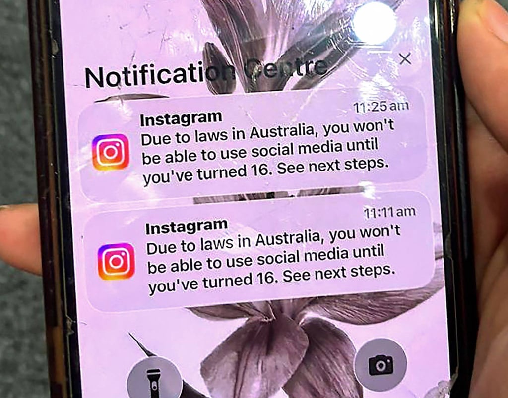 A teenager holds a mobile phone displaying a message from Instagram after the account was locked for age verification in Sydney on December 9, 2025. Photo: AFP