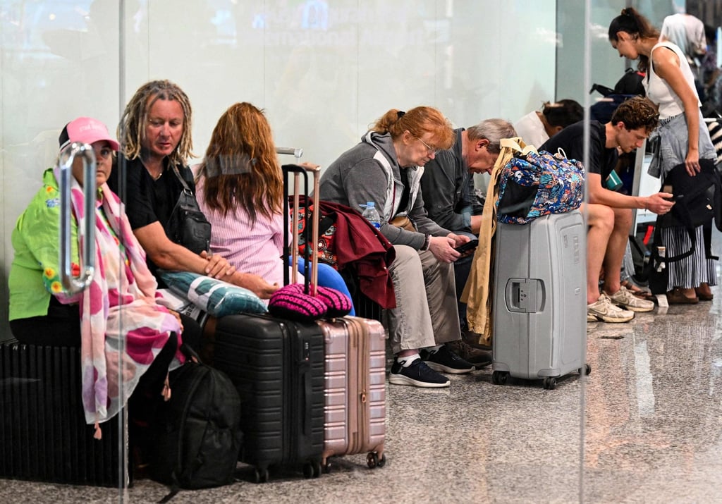 Stranded passengers hang around Bali’s Ngurah Rai International Airport on Monday. Photo: AFP