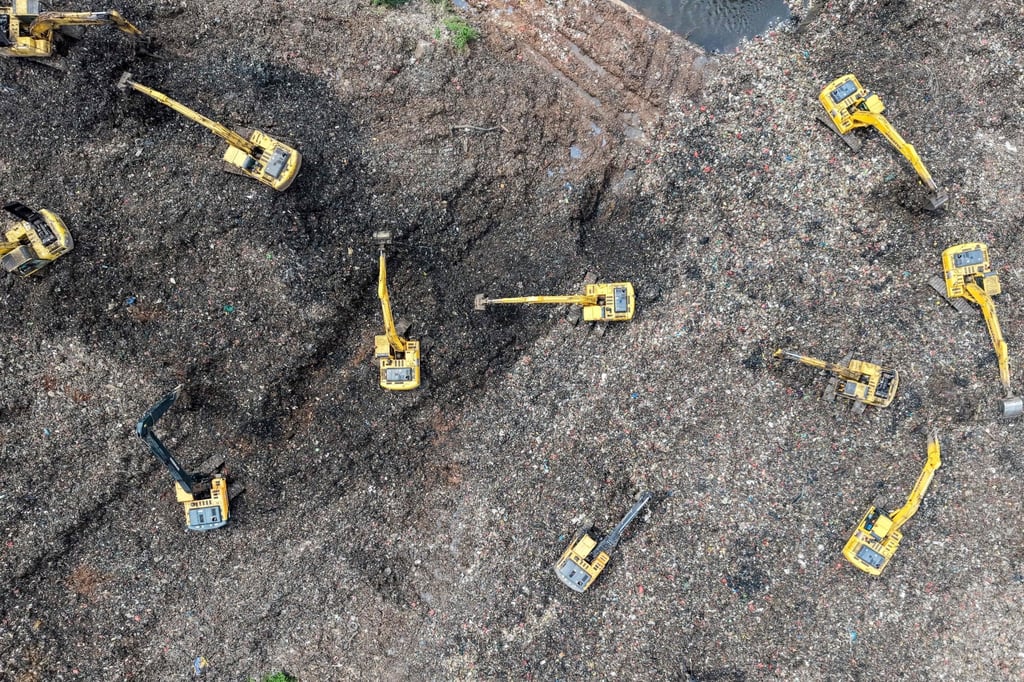 This aerial picture shows a rescue team using heavy machinery to search for missing people following a landslide at a rubbish dump in Indonesia. Photo: AFP