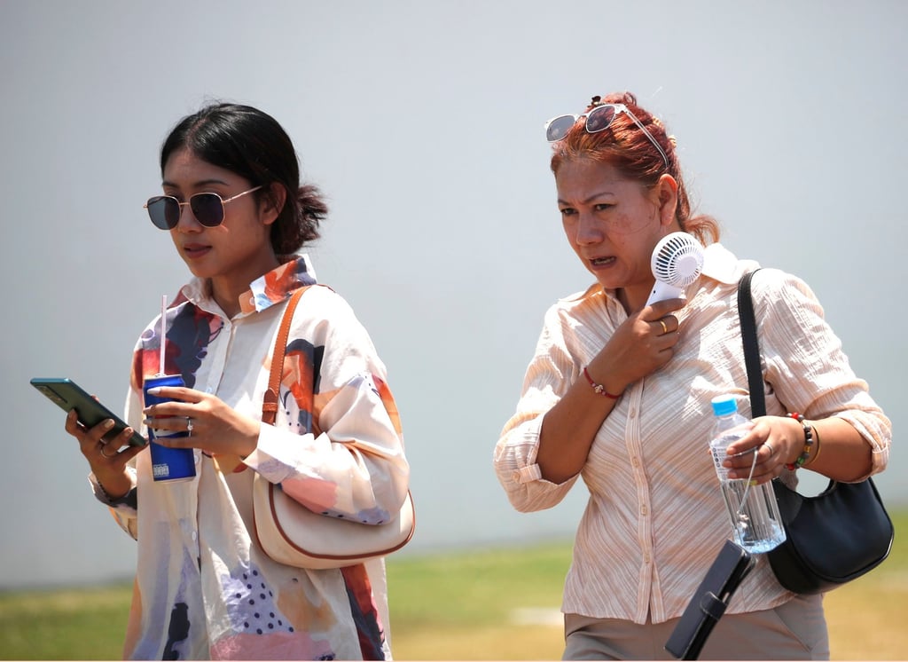 A woman uses an electric fan to cool down during hot weather in Bangkok, Thailand, in April 2024. Photo: EPA-EFE