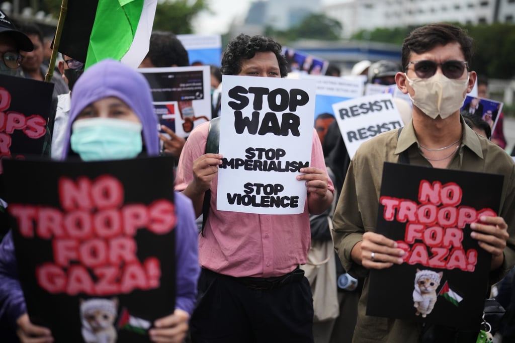 Protesters display posters during a rally against Indonesia’s participation in the US-led Board of Peace, outside the parliament in Jakarta on Friday. Photo: AP
