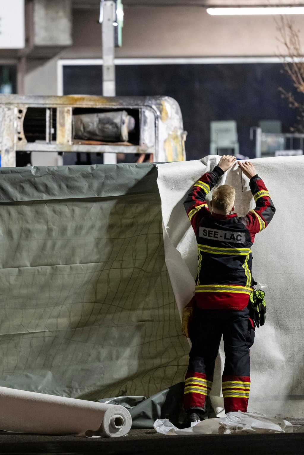 Firefighters close off the area in front of a bus after it caught fire in Kerzers, Switzerland, on Tuesday. Photo: EPA