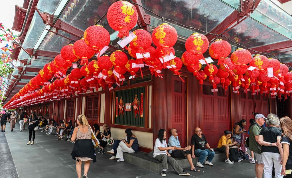 People rest outside the Buddha Tooth Relic Temple, which is decorated with lanterns for Chinese New Year, in Singapore’s Chinatown on February 12. Photo: AFP