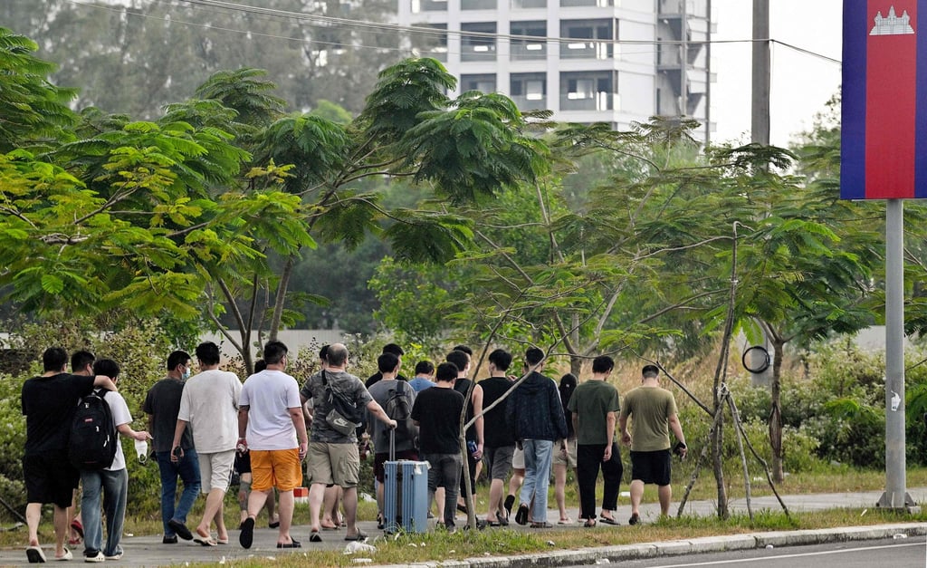 Ex-workers walk out of a suspected scam centre compound in Sihanoukville, Cambodia, on January 15. Photo: AFP