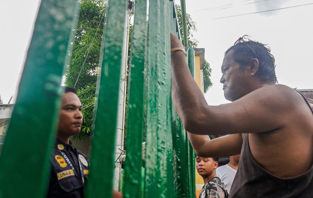People look through the gates of San Jose National High School in Tacloban City, Leyte province, the Philippines, on Monday, following a shooting incident. Photo: EPA