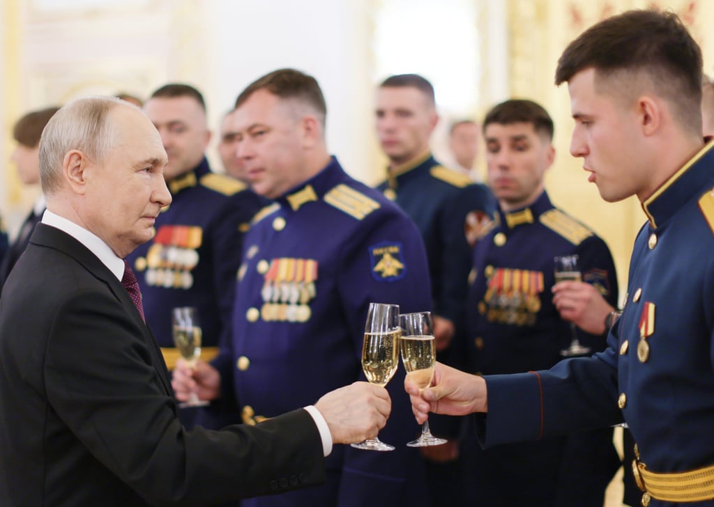 Russian President Vladimir Putin holds up a glass for a toast on Tuesday as he meets graduates of higher education institutions from various ministries. Photo: EPA via Kremlin Pool/Sputnik