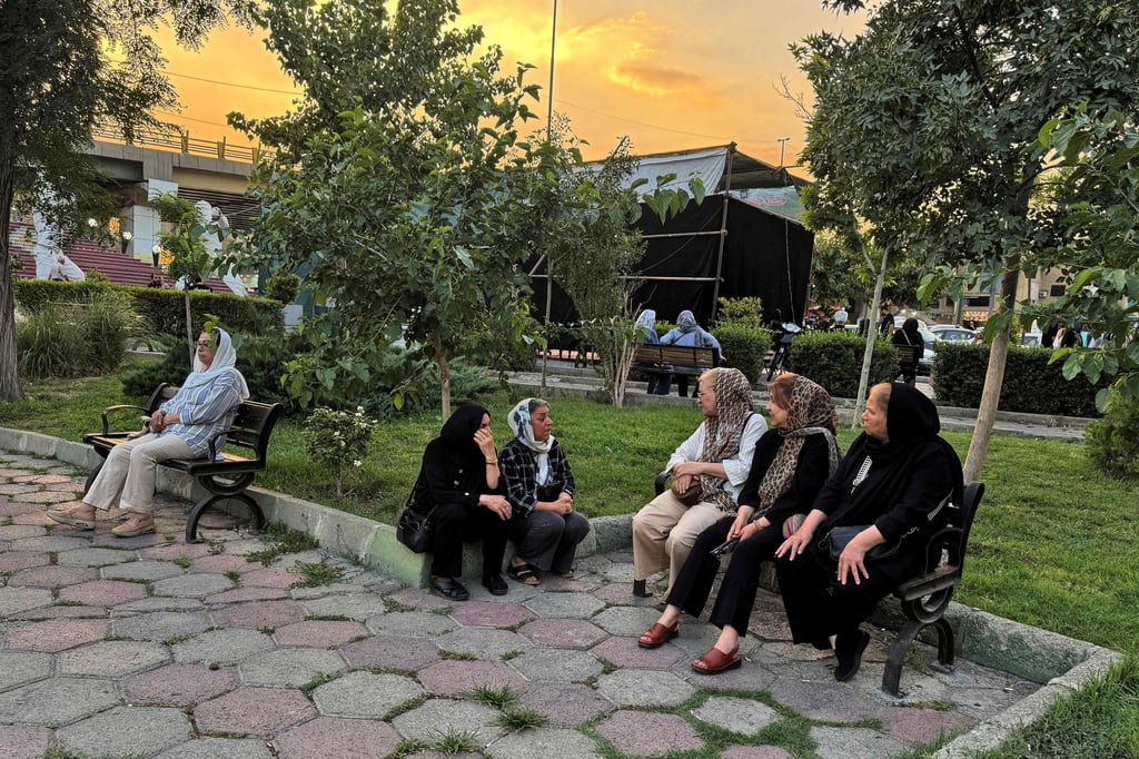 Iranians chat in a park in Tehran on Tuesday. The government must submit a report to the IAEA detailing whether any nuclear material was lost or damaged in US-Israeli strikes. Photo: AFP