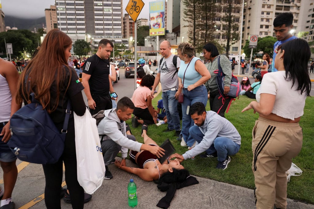 People help a woman after an earthquake in Caracas, Venezuela, on Wednesday. Photo: Reuters