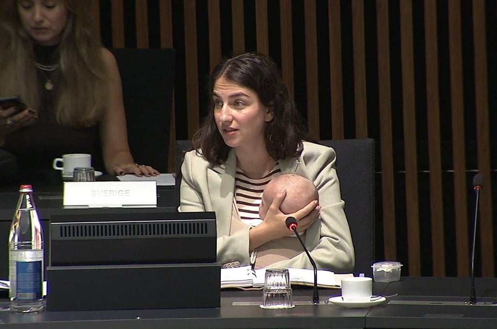 Sweden’s Minister for Environment and Climate Romina Pourmokhtari cares for her child during an EU environment ministerial meeting in Luxembourg. Photo: AFP/EBS/Handout