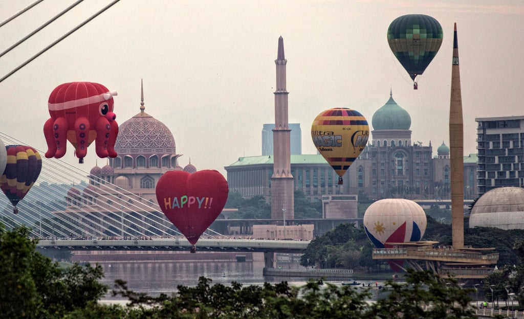 Hot air balloons float near Putra Mosque (left) in Putrajaya, Malaysia. Photo: EPA-EFE