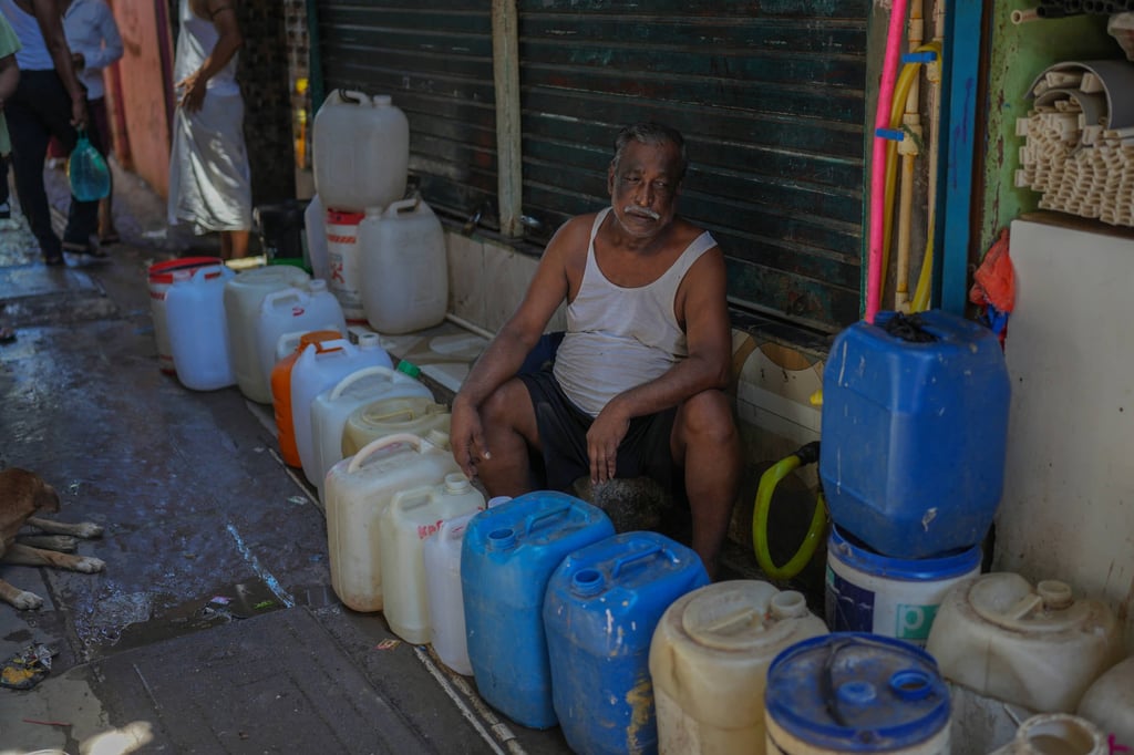 A slum dweller waits to collect water in a narrow lane of a slum settlement in Mumbai, India, last weekend. Photo: AP