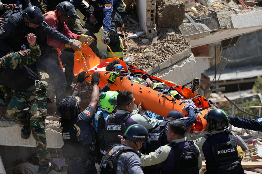 Rescuers pull Moises Calzadilla, 11, from the rubble in La Guaira, Venezuela, on Saturday. Photo: AP