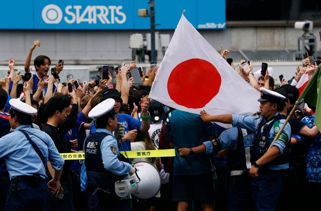 Japanese police officers stand guard in Tokyo on June 21 as football fans gather after the national team’s victory in a World Cup match. Photo: Reuters