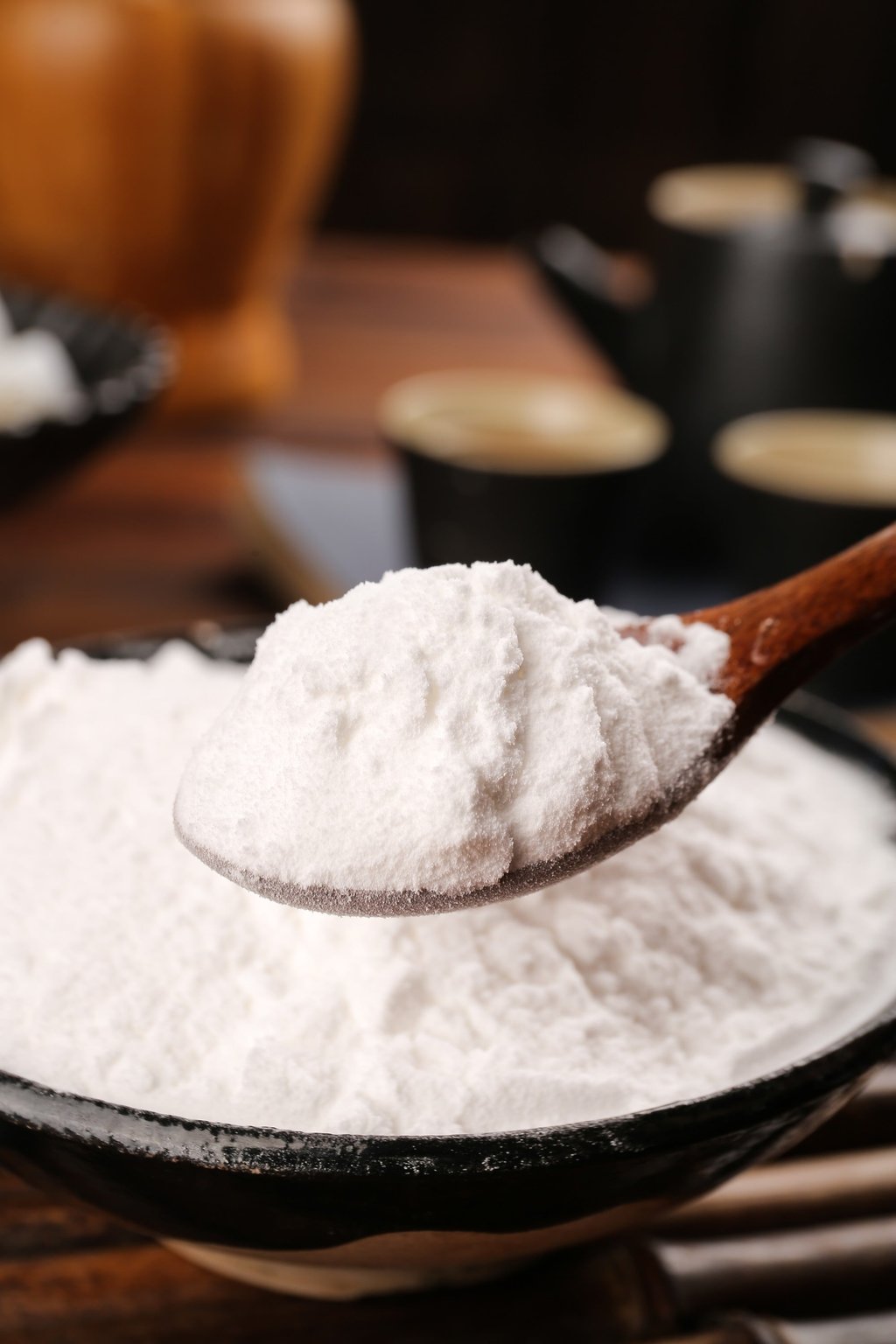 White pea starch powder is seen on a wooden spoon in a cast-iron pan. Photo: Shutterstock