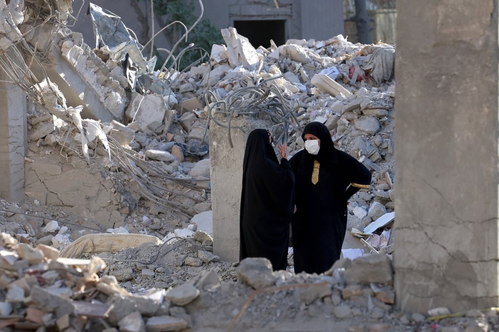 Iranian women chat in early June among the debris of a residential building destroyed by US-Israeli airstrikes. Photo: EPA