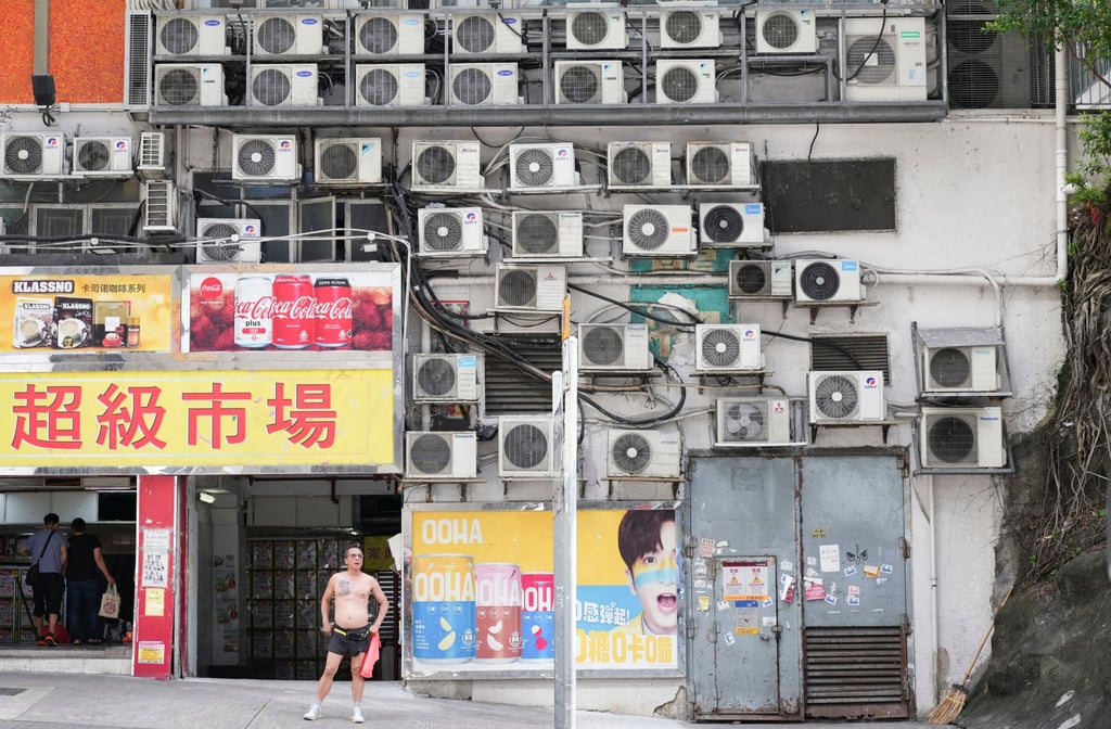 A shirtless man stands in front of a wall of air-conditioner units in Yau Tong in subtropical Hong Kong. Photo: Eugene Lee