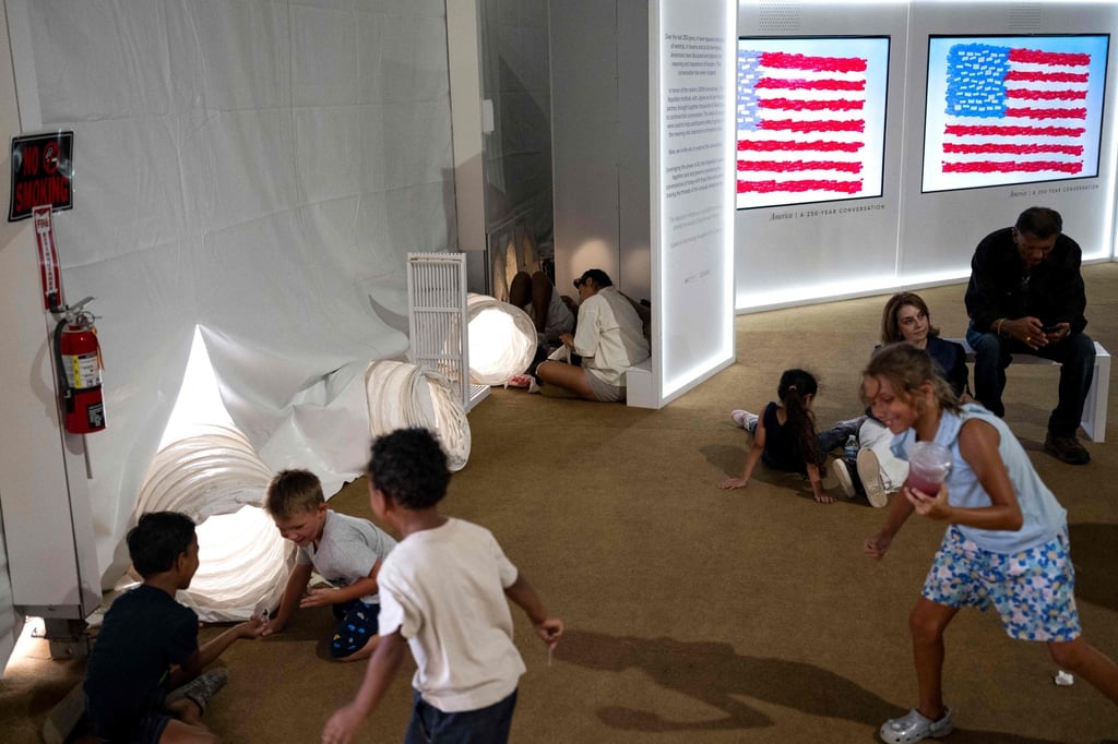 People sit in front of vents pumping cool air into a tent as they visit the Great American State Fair on the National Mall in Washington on Thursday, ahead of the coming July 4 holiday. Photo: AFP