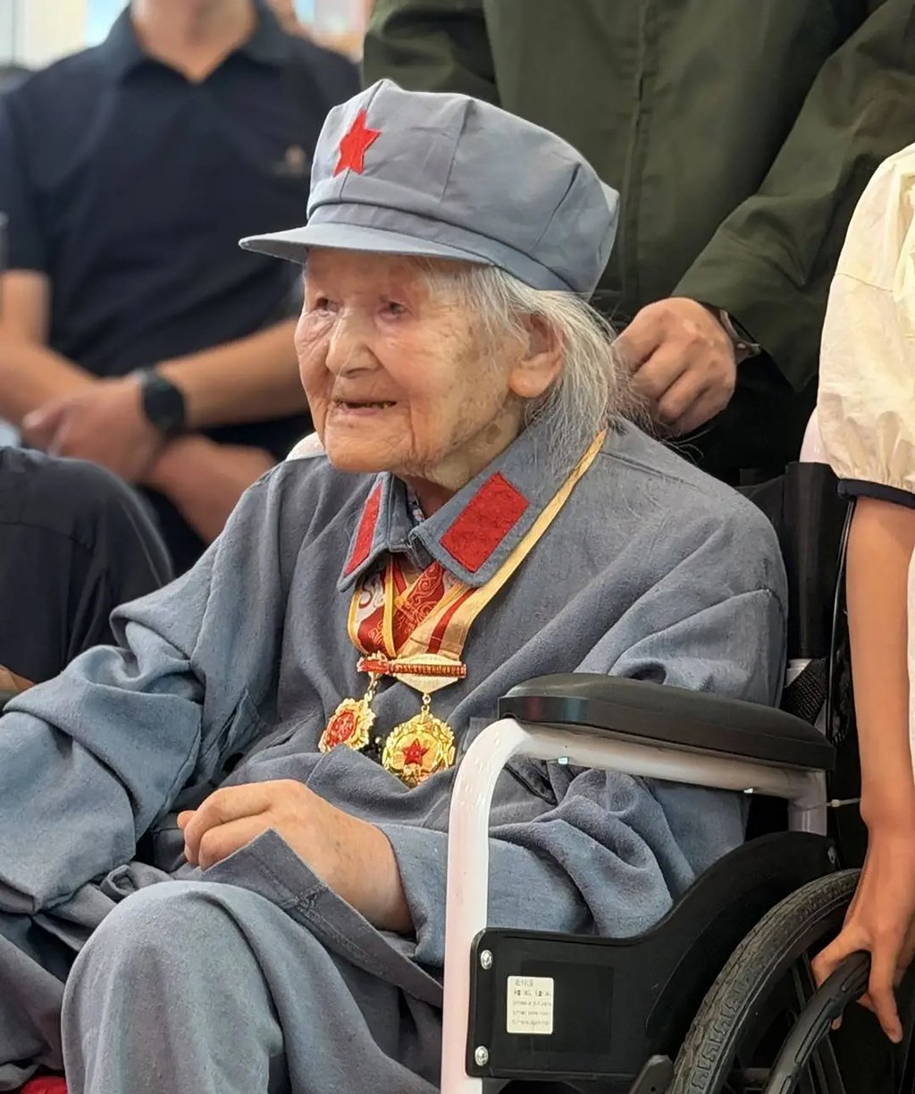 Red Army veteran Wang Quanying, adorned with medals, is surrounded by relatives, volunteers, and well-wishers on June 27 during her 105th birthday celebration. Photo: QQ.com