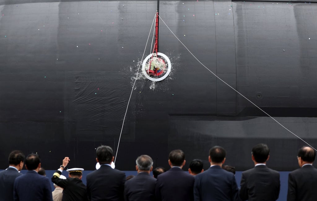 A bottle of champagne is smashed on the hull of South Korea’s first 3,600 tonne-class naval submarine during a ceremony at the Hanwha Ocean dockyard on October 22, 2025. Photo: Yonhap/EPA
