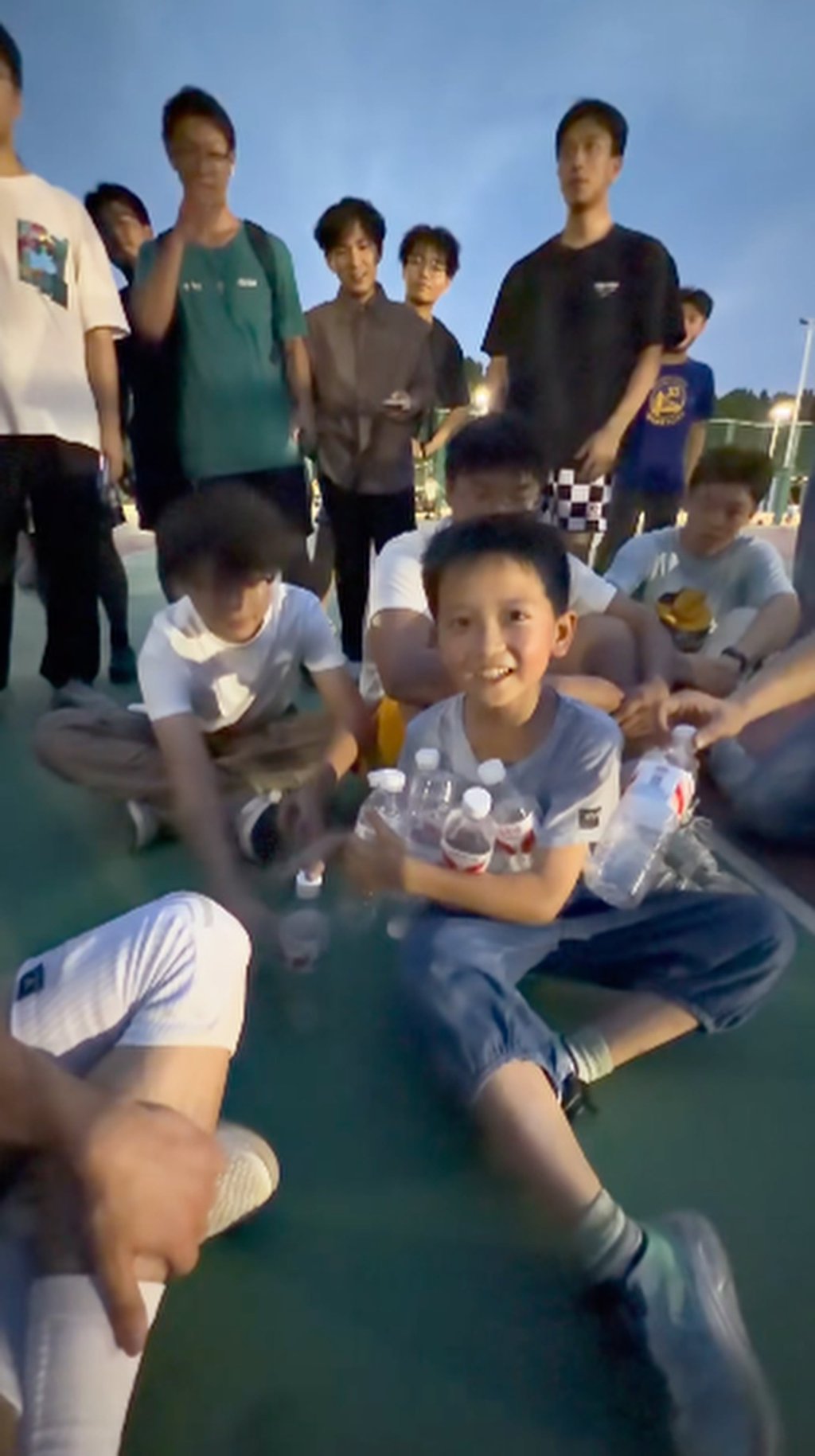 Noticing students holding empty drink containers, he confidently stepped forward to pitch his mother’s business — and received instant, overwhelming support. Photo: Douyin