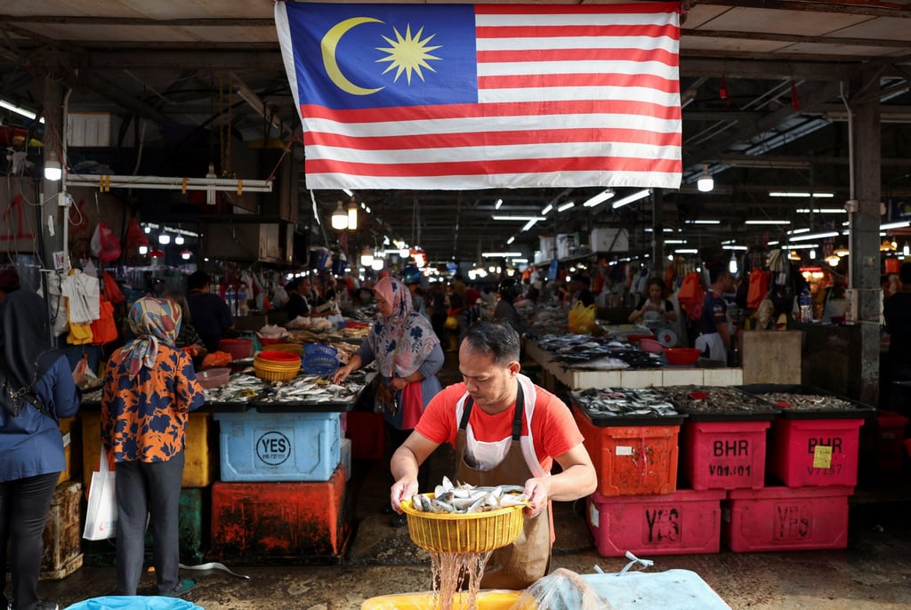 A fishmonger holds a basket of fish at a wet market in Kuala Lumpur, Malaysia. In May, Thailand restricted the import of Malaysian-caught sea bass due ‌to concerns over chemical residues. Photo: Reuters