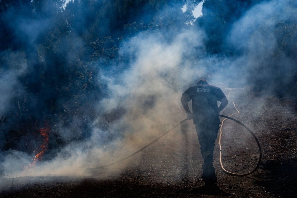 A firefighting helicopter works on extinguishing a wildfire between Can Tries and the Serra de Ferreres in Spain on Wednesday. Photo: via ZUMA Press Wire/dpa