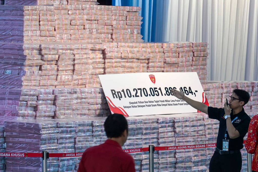 Officials from the Attorney General’s Office prepare a pile of Indonesian banknotes totalling around US$587 million – recovered from various corruption cases and environmental fines – before a ceremony for its handover to the government on May 13. Photo: AFP