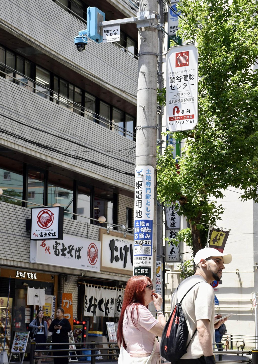People walk past a security camera equipped with facial recognition AI outside the JR Nippori Station in Tokyo’s Arakawa ward in May. Photo: Kyodo